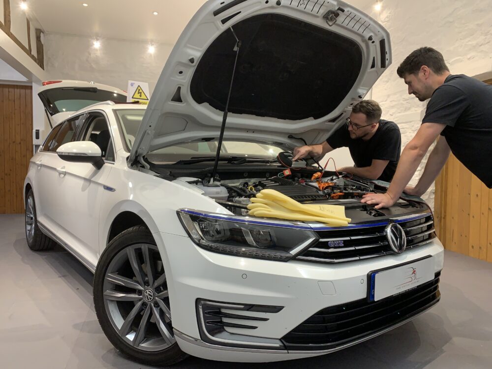 2 learners conducting tests on the AC charging circuit of a Toyota PHEV Prius.